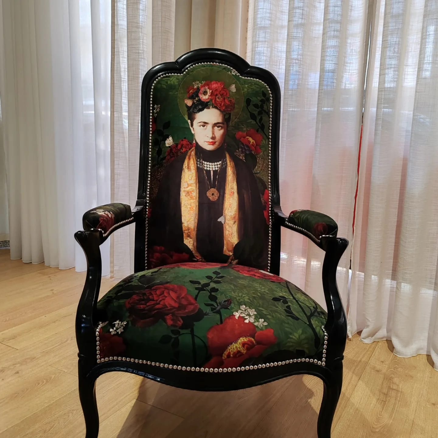 Cadeirão Voltaire lacado a preto e estofado com tecido estampado com um retrato e rosas vermelhas